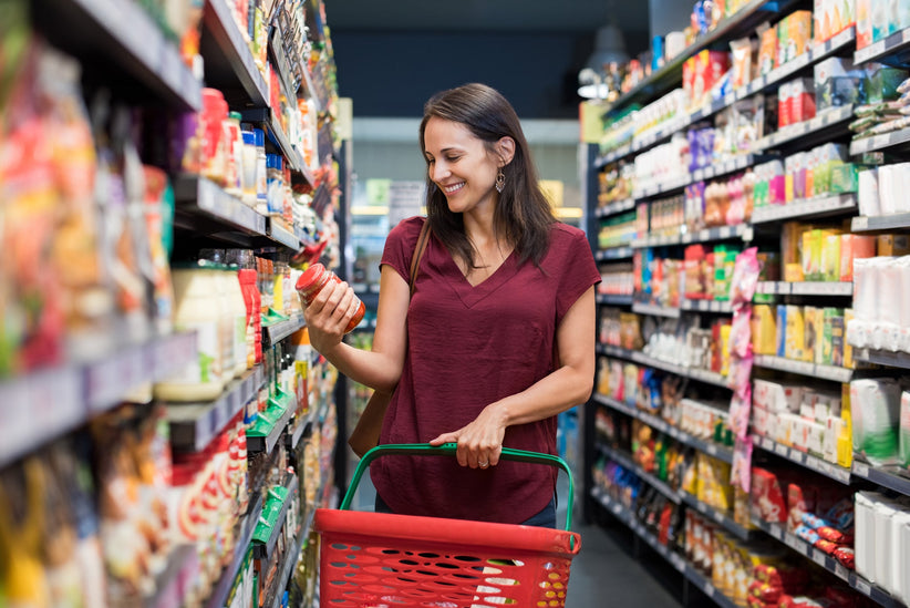 Grocery store shopping, woman holding food in her hand. She is happy and glad to be healthy